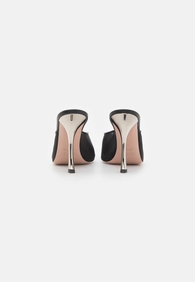 Sorte højhælede sko med en glat overdel, blank metalhæl og en beige indersål, der har en slip-on design og rund bag.