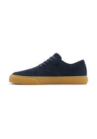 Zapatillas de ante en color navy con un diseño de bajo, puntera redonda y suela de goma. Seis ojales con cordones a juego, estilo minimalista sin marcas visibles.