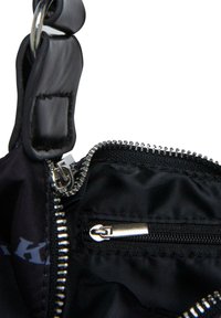 Interno di una borsa in tessuto nero, con un comparto principale dotato di una cerniera argentata e una tasca interna più piccola con una cerniera nera.