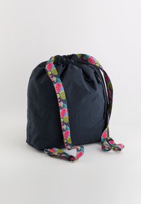 Sac de umăr de culoare albastru închis, cu sfoară de strângere, având bretele colorate cu modele florale și de fructe. Fabricat dintr-un material ușor, cu o textură moale.