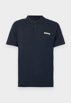 Navy blue polo shirt made of soft cotton, featuring a three-button placket, short sleeves, and a logo patch on the chest with contrasting stripes.
