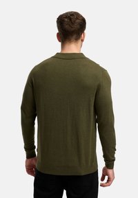 Olivegrøn strikket trøje med lange ærmer, ribbede manchetter og kant, samt en flad krave. Stoffet fremstår blødt med en subtil tekstur.