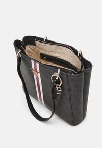 Sac à main noir avec doubles poignées, devant rayé, ferrures dorées et ouverture supérieure dévoilant un intérieur beige avec compartiments zippés et logos de la marque.