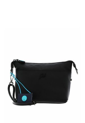 Petit sac bracelet en cuir noir avec fermeture éclair et petite étiquette bleue attachée avec un bouton, présenté sur fond blanc.
