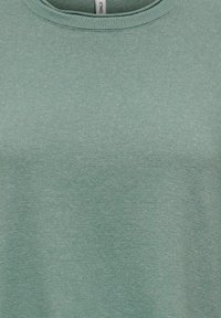 Chemise vert clair côtelée à col rond, fabriquée en matériau doux et texturé. Présente un motif de tricotage uniforme sur toute la surface.