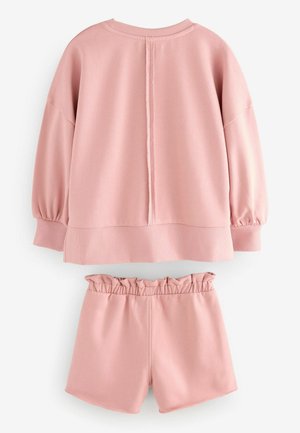 Rosa sweatshirt med sänkta axlar och ribbade muddar, tillsammans med matchande shorts med ett rynkat midjeband. Slät, elastisk tyg.