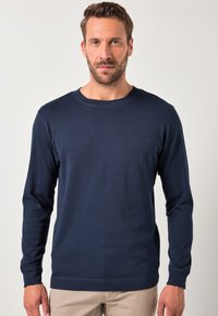 Marineblaues Langarmshirt aus weichem Baumwollstoff mit Rundhalsausschnitt, das über eine glatte Textur und einfache Nahtdetails verfügt. Schlichte Gestaltung ohne Muster.