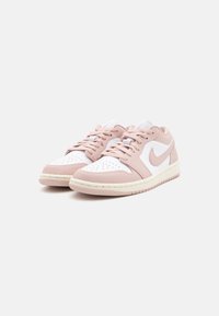 Baskets Nike avec un dessus en cuir blanc et rose clair, boîte à orteils perforée et semelle en caoutchouc crème. Comprend des lacets rose clair.