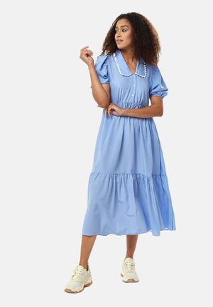 Light blue, knee-length dress with puff sleeves, button-down front, and white collar trim. Flowing fabric with gathered waist and tiered skirt.