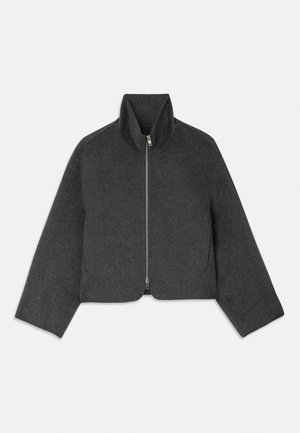 Beskuren, grå ulljacka med hög krage och framdragkedja. Har vida ärmar och en ren, minimalistisk design. Mjuk textur.