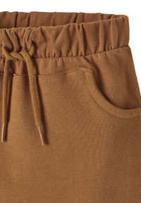Braune Jogginghose mit elastischem Bund und Kordelzug, seitlichen Taschen und weichem Stoff. 