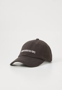 Black baseball cap with a curved brim, featuring white embroidered text that reads "Nothing for Beautiful People." Cotton material.