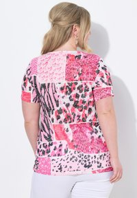 Kortärmad skjorta med ett lapptäcke design i rosa nyanser, djurmönster och hjärtformade mönster. Tillverkad av mjukt tyg med en avslappnad passform.