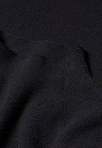 Tissu noir en maille avec une texture douce, présentant un col côtelé et une finition lisse, indiquant un design classique et décontracté.