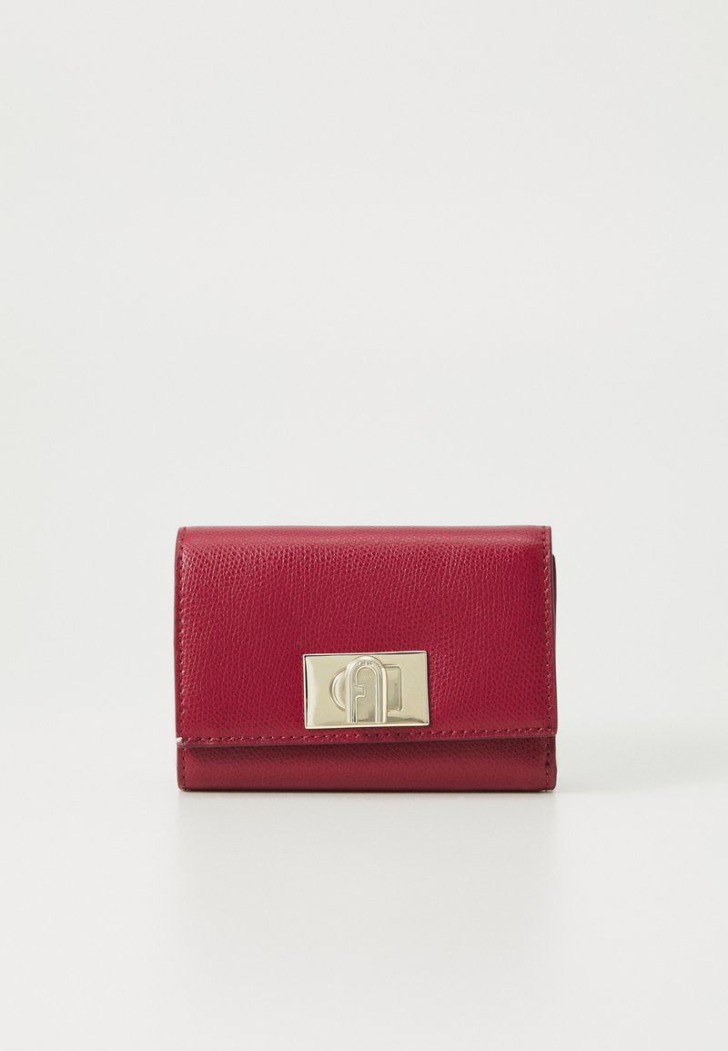 Portefeuille en cuir rouge avec une finition texturée, présentant un fermoir doré. Forme rectangulaire compacte avec des bords arrondis. Design minimaliste.