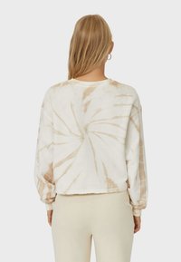 Przycięta bluza tie-dye w kolorze białym i jasnobeżowym, z długimi, obszernymi rękawami i surowym wykończeniem. Miękka bawełniana tkanina z teksturowanymi wzorami.