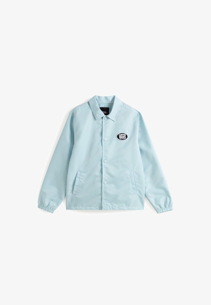 Veste bleu clair en tissu lisse, dotée d'un col, de boutons-pression, de deux poches latérales et d'un patch logo Vans noir sur la poitrine gauche.