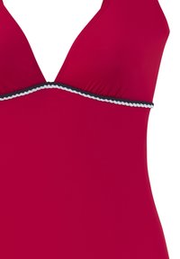 Punainen uimapuku, jossa on syvään uurrettu pääntie ja mustavalkoinen reuna. Valmistettu sileästä materiaalista, jossa on koottua tekstiiliä bodice-osion ympärillä.