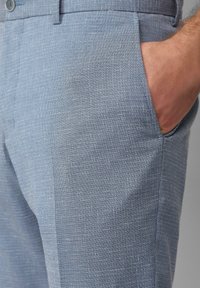 Helle blaue Hose mit einem strukturierten, karierten Muster. Verfügt über eine Seitentasche und einen lockeren Schnitt, hergestellt aus leichtem Stoff.