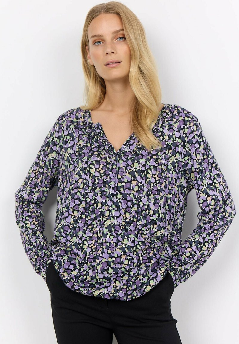Long-sleeve blouse in dark fabric with a floral print featuring purple, green, and white. V-neckline and loose fit with a slightly gathered hem.