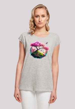 Graues T-Shirt mit hochgerollten Ärmeln, das eine farbenfrohe Grafik eines Baumes und einer Landschaft mit rosa Blüten und Vögeln zeigt. Weicher Stoff.