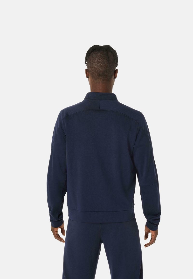 Pullover blu navale con colletto alto, tessuto morbido e maniche lunghe, caratterizzato da un delicato dettaglio di cucitura lungo le spalle.