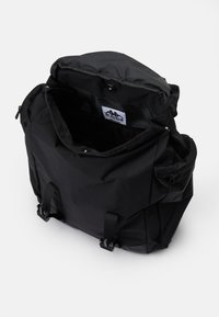 Zwarte rugzak van nylon met een gestructureerd oppervlak, voorzien van een ritssluiting bovenaan, verstelbare schouderbanden en interne vakken voor organisatie.