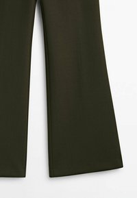 Pantalons larges en vert olive foncé, fabriqués en tissu lisse avec un devant plat, sans quincaillerie ni embellissements visibles.