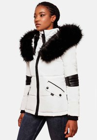 White puffer jacket with a black faux fur hood trim, black leather accents on sleeves, zip closure, and a side pocket with a flap.