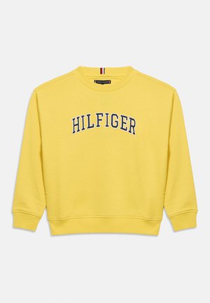 Gul genser med rund hals og lange ermer, med "HILFIGER" brodert i marineblått over brystet og ribbestrikkede mansjetter og kant.