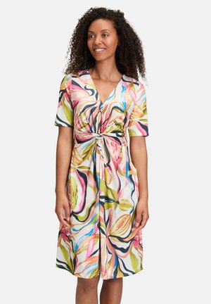 Knie-lange jurk van lichte stof met een kleurrijk abstract patroon van spiraalvormige roze, groene en blauwe kleuren; V-hals en korte mouwen.