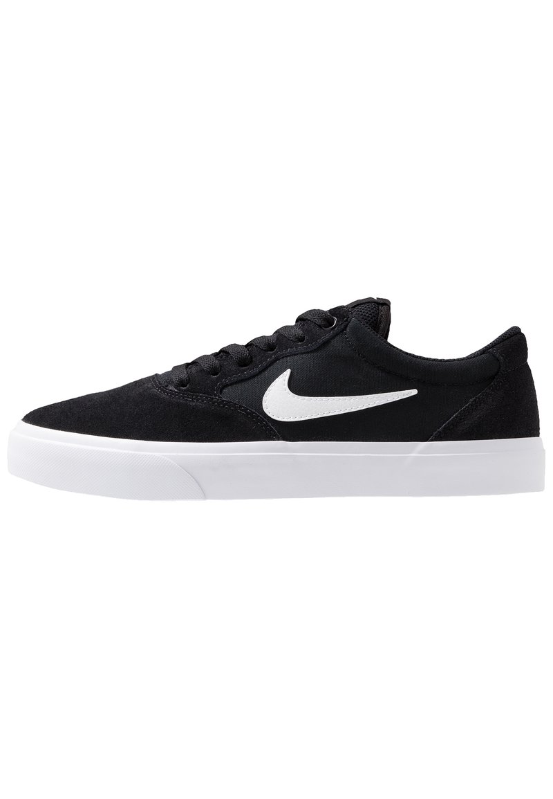 Černé semišové tenisky s bílými gumovými podrážkami, které mají na straně bílé logo Nike, kulatou špičku a klasický design na šněrování.