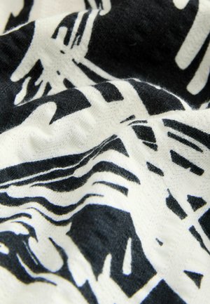 Abstrakcyjna tkanina czarno-biała z falistymi liniami i wzorami. Materiał jest miękki o gładkiej fakturze, co tworzy wizualną głębię.