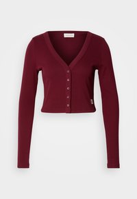 Cardigan scurt burgund cu decolteu în V, mâneci lungi și șapte nasturi în față. Fabricat dintr-un material elastic, având un design ajustat.