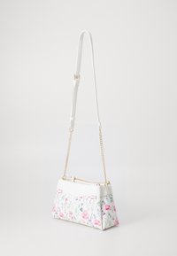 Torebka w kwiatowy wzór z białą podstawą z eko skóry, złotym łańcuszkowym paskiem i zapinana na zamek u góry, zdobiona różowymi i niebieskimi kwiatami.