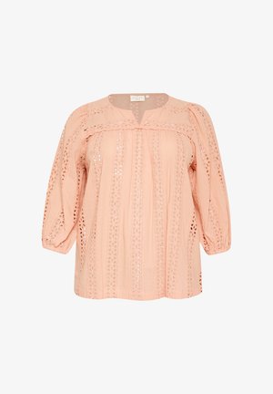 Blouse rose avec des manches 3/4, présentant des découpes en dentelle et une coupe décontractée. Le tissu a une texture douce et une apparence légère.
