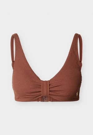 Soutien-gorge en tissu texturé marron avec bretelles fines ajustables et fermeture par bouton-pression à l'avant, présentant un léger effet froncé au centre.