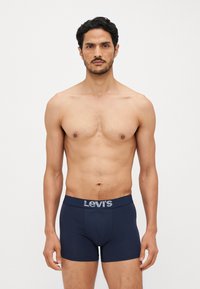 Boxer-briefs bleu marine en coton avec une texture douce. Équipés d'une ceinture avec le logo gris de Levi's. Conçus pour un silhouette ajustée.