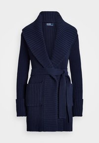 Námořnický pletený kardigan s hřejivým kloboukem, dvěma předními kapsami, zavazováním v pase a dlouhými rukávy. Texturovaná tkanina přidává hloubku.