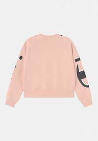Felpa rosa chiaro con maniche raglan. Presenta una grande grafica nera e accenti circolari sulle maniche. Materiale morbido, design corto.