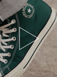 Rohelise lõuendist kõrgete säärega toss valgete paelte ja kontrastse valge kummist tallaga. Omaduseks trükitud tähelogo ja mustad detailid.