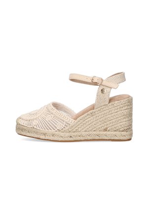 Zapato de cuña de esparto beige con bordados decorativos y tira al tobillo. El zapato cuenta con una suela de yute trenzado y una parte superior de tela texturizada.