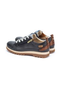 Leather casual shoes with a black upper, brown accents, white laces, and a textured rubber sole. Features side zipper for easy wear.