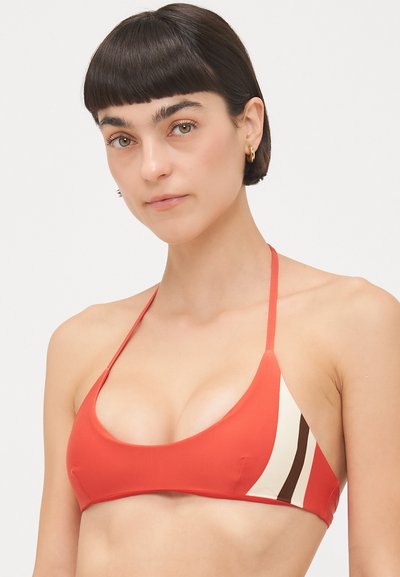 Sarkans bikini tops ar trīsstūrveida krūšturiem, ar krēmkrāsas un brūnām svītrām vienā pusē. Izgatavots no gludas, elastīgas vielas ar plānām siksnām.