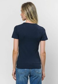 Námornícky modré rebrované tričko s krátkymi rukávmi a okrúhlym výstrihom, vyrobené z mäkkej látky, priliehavý strih, zobrazené zozadu.