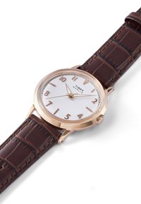 Bruin leren armbandhorloge met een roségouden kast, witte wijzerplaat en gedurfde bruine uurmarkeringen. Heeft een klassieke ronde vorm en een minimalistisch ontwerp.