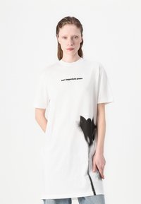 Balta per didelė medvilninė tees su juodu tekstu "karl lagerfeld jeans" ir juoda gėlių grafika priekyje.