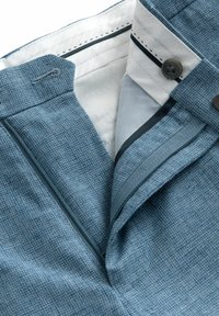 Blue textured fabric pants with a white lining, featuring a zipper closure, button detail, and contrasting stitching.