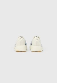 Pair of white and gray Adidas sneakers viewed from the back, set against a plain white background.