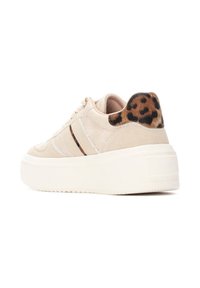 Zapatillas de plataforma de ante beige con rayas blancas, suela texturizada en color crema y un acento de estampado de leopardo en el talón.
